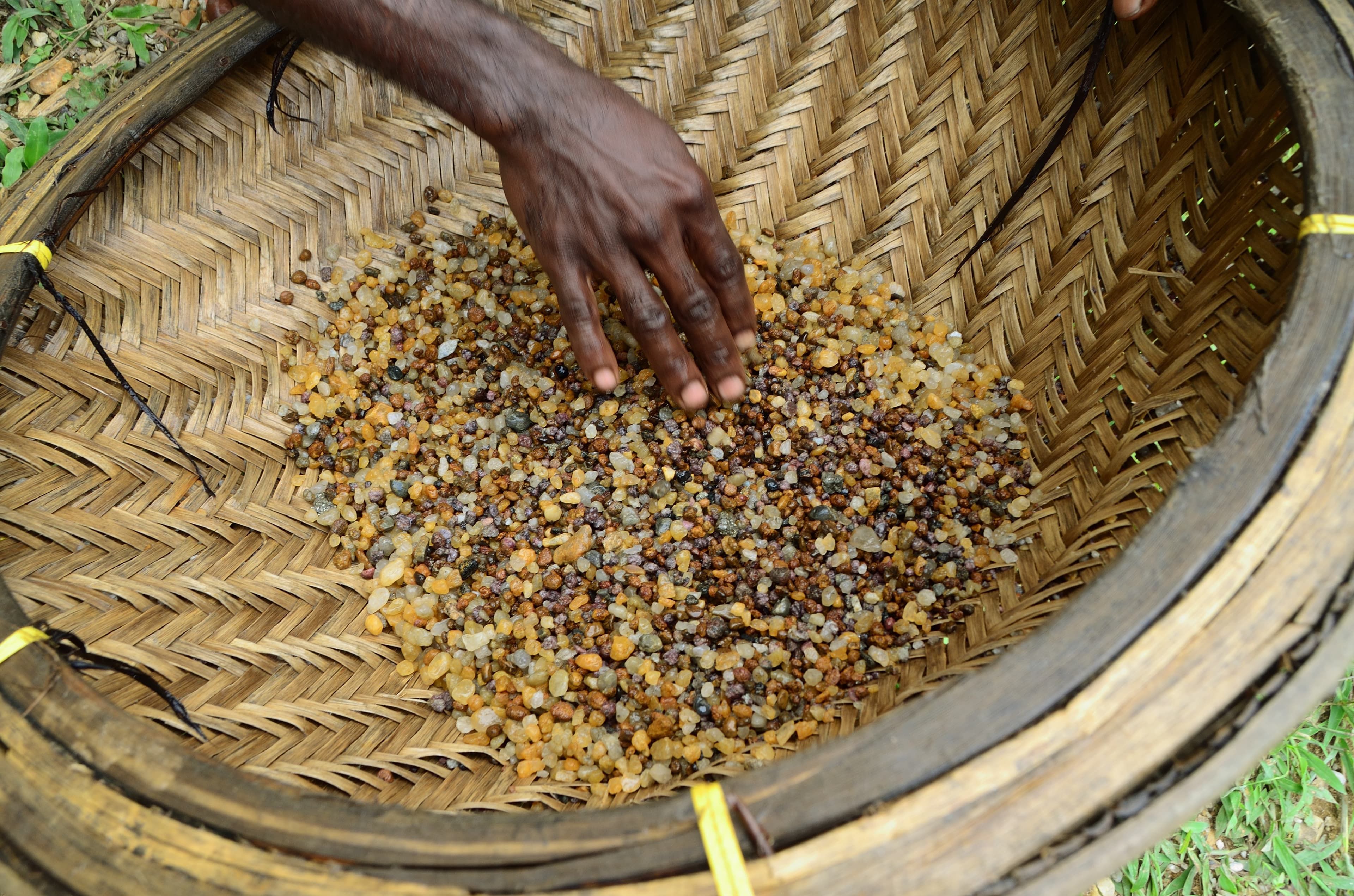 Hand sorting gemstones in a traditional basket